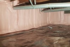 Encapsulated crawl space featuring spray foam insulated foundation walls, floor vapor barrier, and overhead HVAC ductwork by Classic Spray Foam.