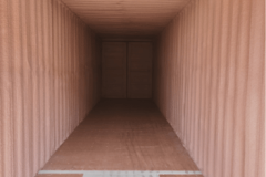 Alt Text: Interior of a steel shipping container fully insulated with closed-cell spray foam insulation on corrugated walls, ceiling, and doors by Classic Spray Foam.