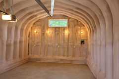 Complete interior view of an arched Quonset metal shop insulated with spray foam, featuring garage door track and end-wall framing by Classic Spray Foam.
