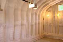 Arched Quonset hut building interior fully insulated with closed-cell spray foam insulation applied by Classic Spray Foam.