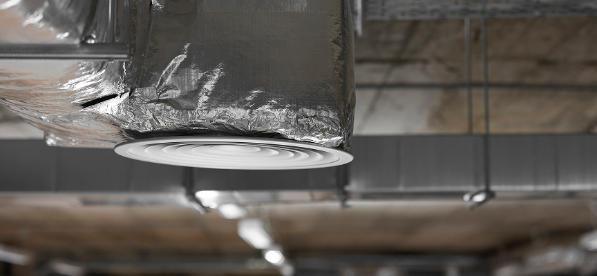 Foil-wrapped commercial HVAC ductwork with a circular air diffuser, demonstrating office insulation for acoustic control and indoor air quality by Classic Spray Foam.